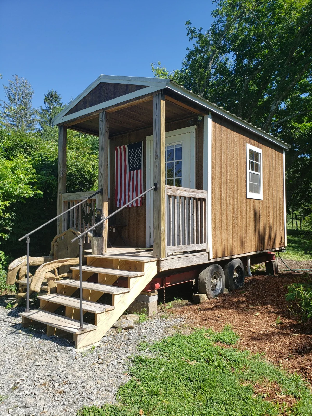 Tiny home on a trailer surrounded by trees