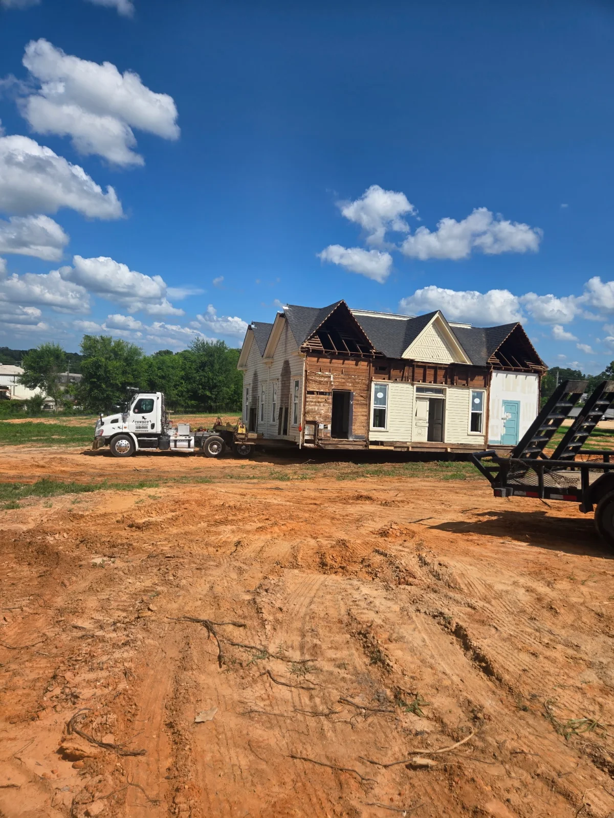 Cowboy House Movers relocating a detailed wood-frame house